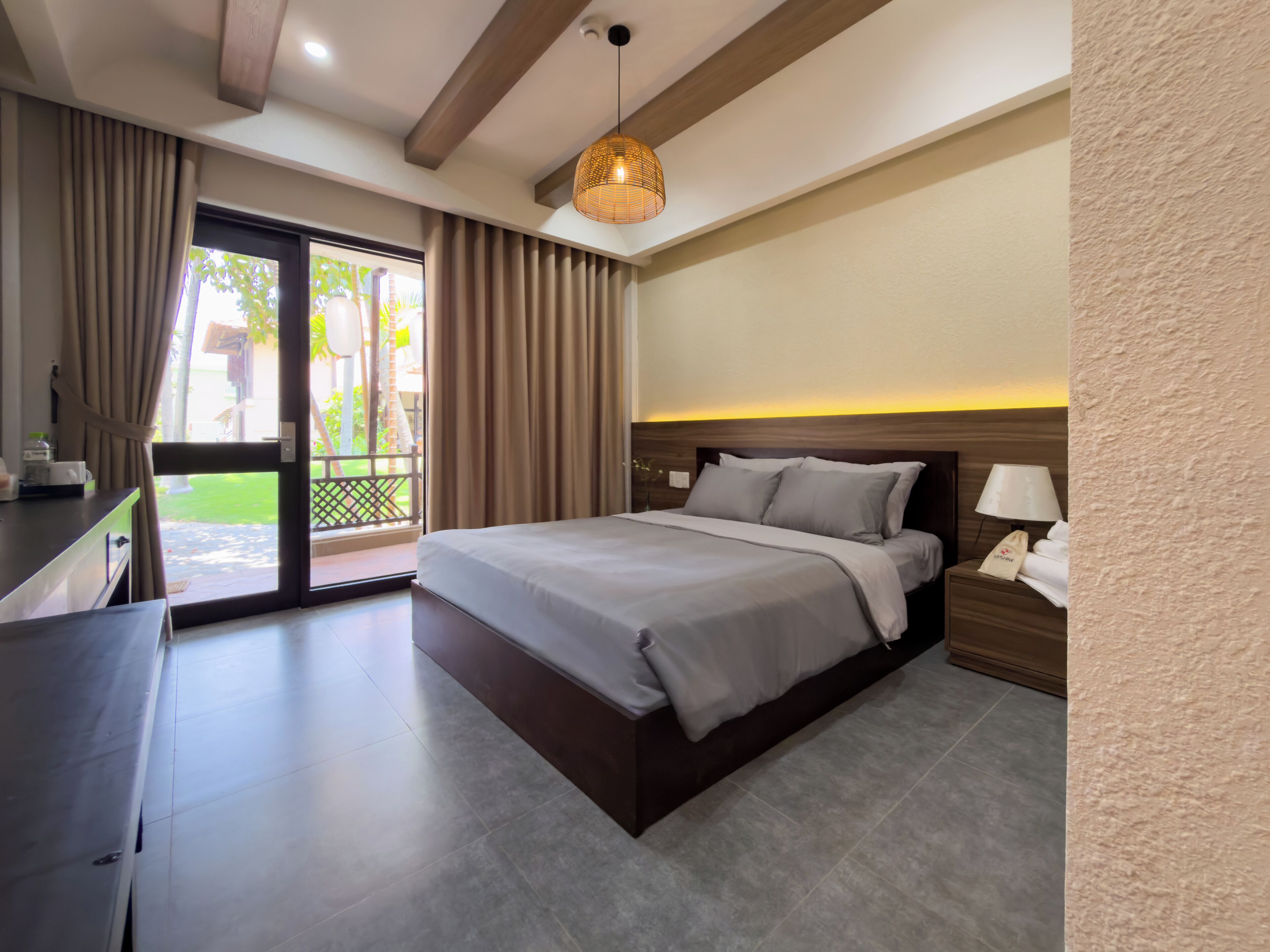 Een hotelkamer met een bed, een bureau, een lamp en uitzicht op de omgeving.