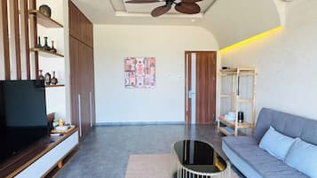 Suite Luxury, balcone, vista spiaggia | Area soggiorno | TV a schermo piatto 4 pollici con canali via cavo