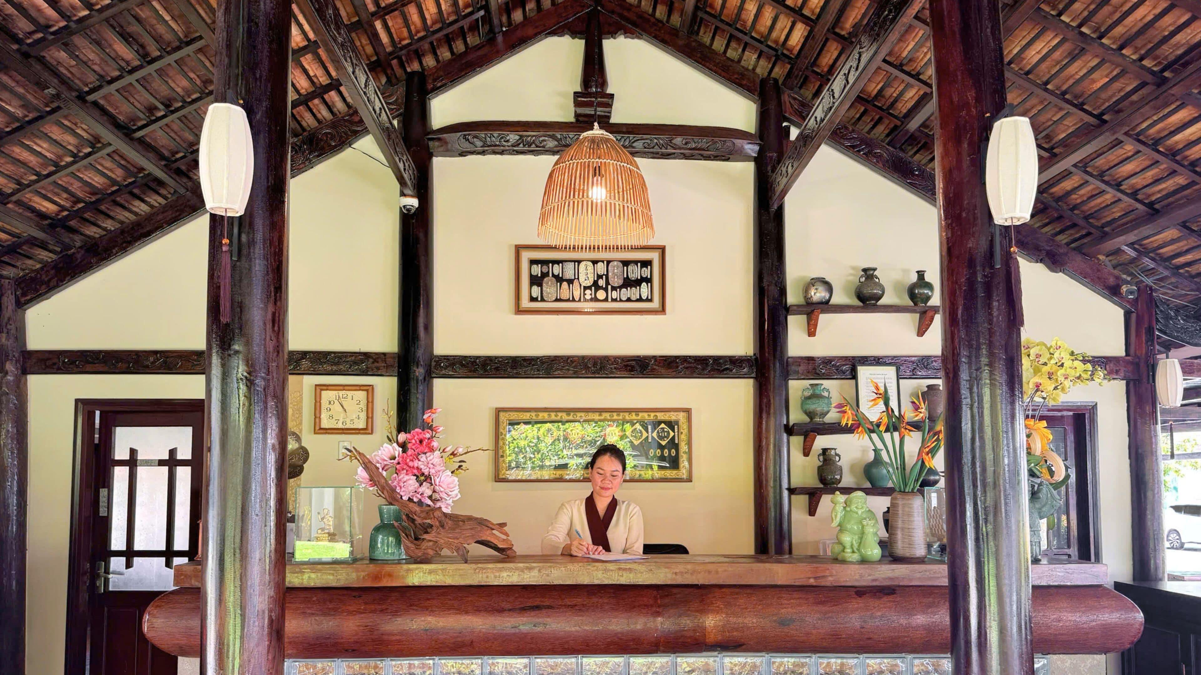 A reception desk with a clock, framed artwork, and decorative vases.
