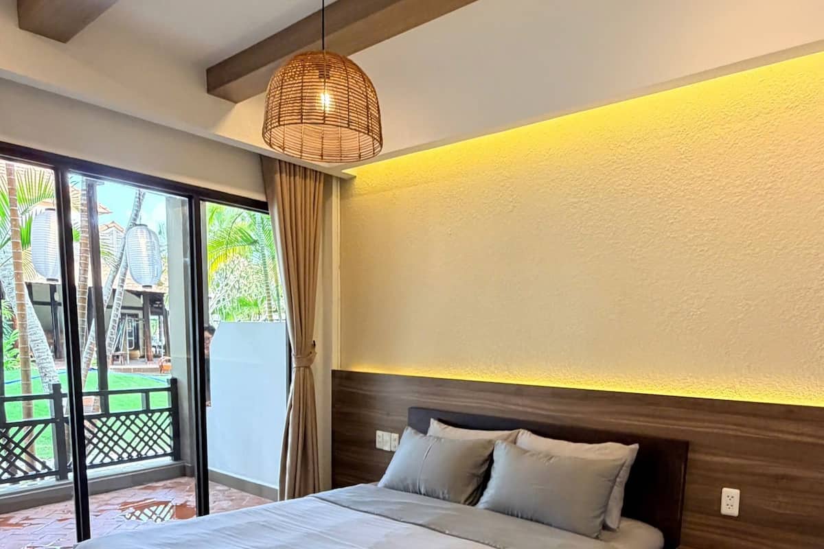 A modern bedroom with a large bed, a wooden headboard, and a ceiling light fixture.