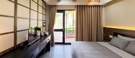 A hotel room with a bed, a desk with a computer, a lamp, and a view of the outdoors.