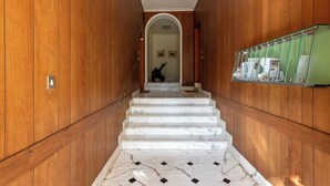 Eine Marmortreppe mit Holzvertäfelung an den Wänden führt zu einem Raum mit grüner Wand und einem Bulletin Board.