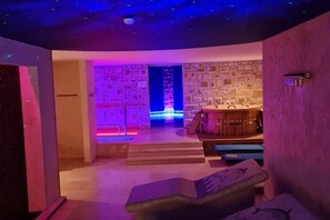 Ein Wellnessbereich mit Steinwand, einer Holzbank und einer Rezeption.