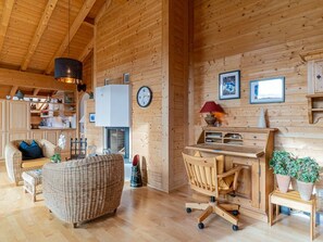 A cozy wooden interior with a wicker sofa, a desk with a chair, and a fireplace. - Mira Flem, (Flims Dorf), by Interhome (Flims)