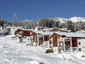 A snow-covered mountain resort with wooden buildings and ski slopes. - Mira Flem, (Flims Dorf), by Interhome (Flims)