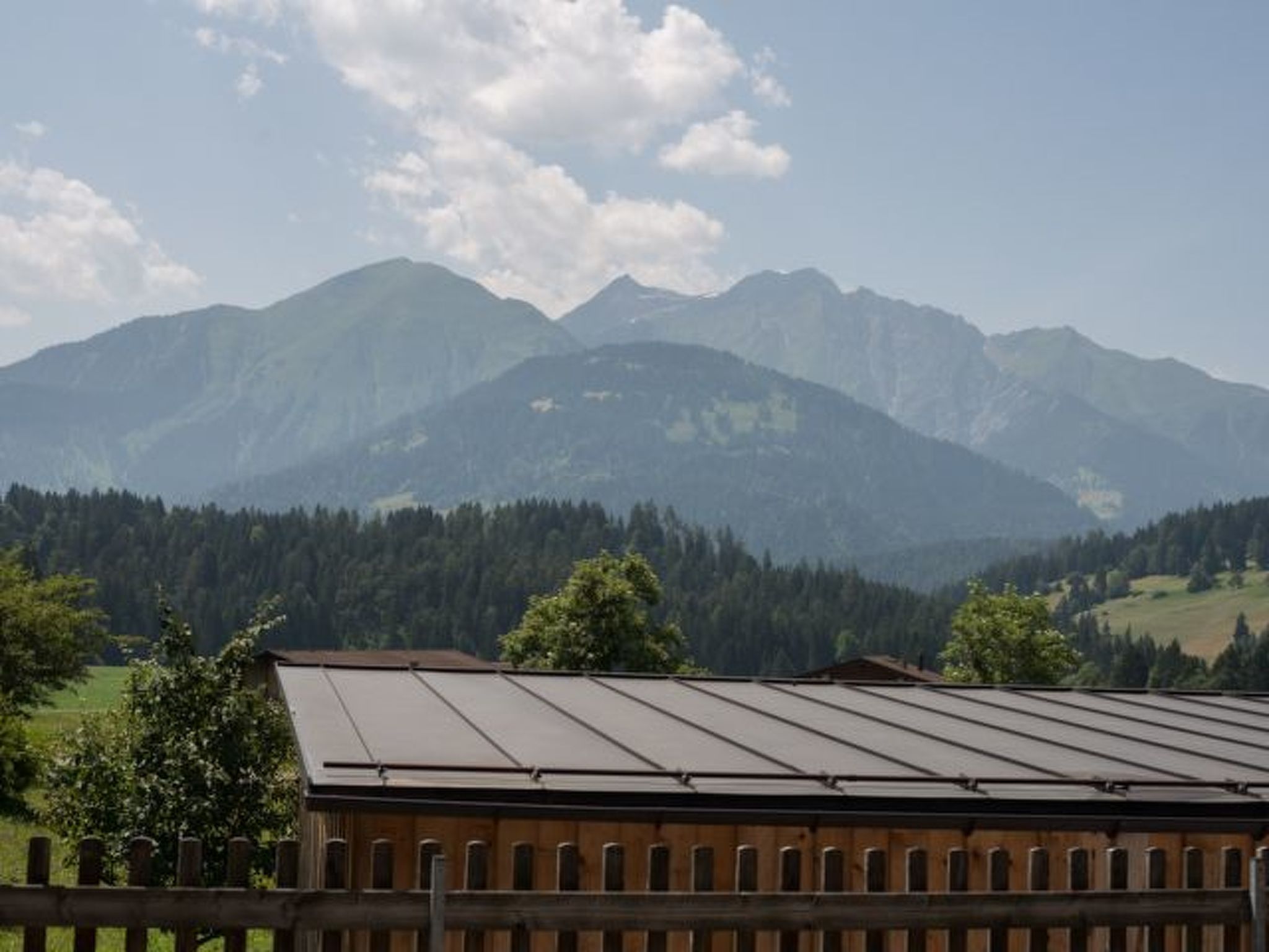 A mountain landscape with a building in the foreground.