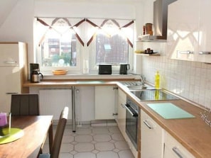 A kitchen with a window, a coffee maker, a microwave, and a sink. - MeerZeit by Interhome (Rehburg)