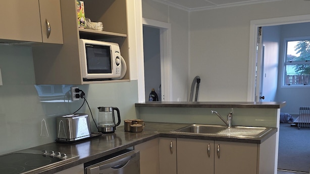 A modern kitchen with stainless steel appliances, a microwave, a toaster, and a sink.