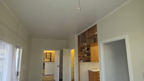 A spacious living area with a kitchen, a dining area, and a visible door leading to another room.