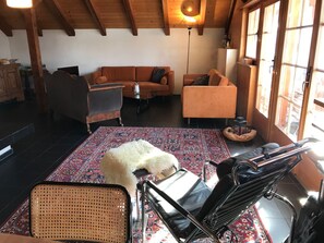 A cozy living room with a sofa, armchairs, a coffee table, and a rug.