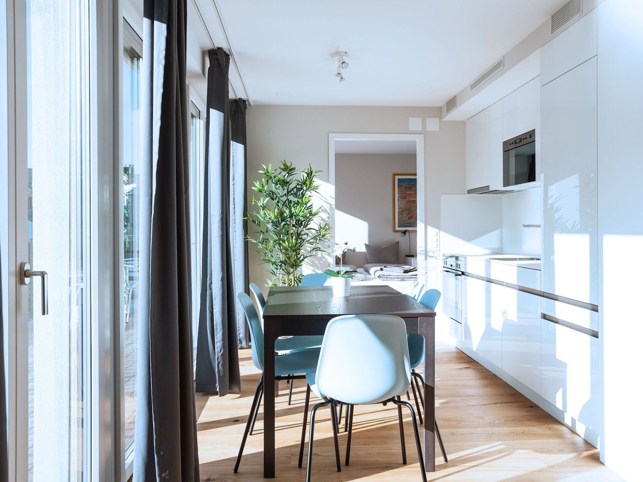 A modern kitchen with white cabinets and a built-in oven.