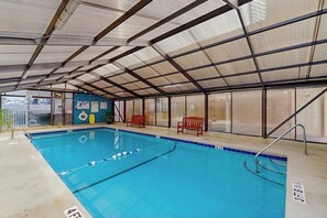Ein Hallenbad mit Metallveranda, Bänken und einem übersichtlichen Beckenbereich.