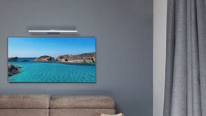 A living room with a sofa, a coffee table, a flat-screen TV, and a grey curtain. - Modern 1BR APTS near Manoel & Tigne (Gżira)