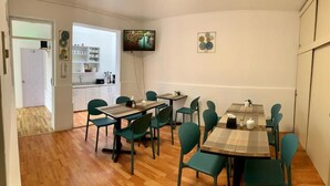 En matplats med en tv, ett kök i bakgrunden och ett trägolv.