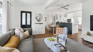 Uma sala de estar moderna com um sofá, mesa de centro e um espaço para refeições.