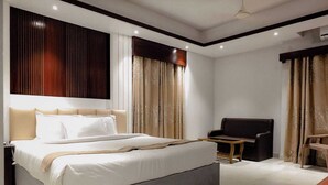A modern hotel room with a large bed, a seating area, and a desk. - Honeymoon Resorts Cox's Bazar (Cox's Bazar)
