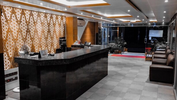 A modern reception area with a black reception desk, a patterned wall, and leather seating. - Honeymoon Resorts Cox's Bazar (Cox's Bazar)