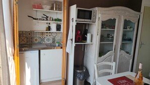 A kitchen with a microwave, stove, and various kitchenware. - Bright studio apartment near the beaches – Portiragnes Village (Portiragnes)