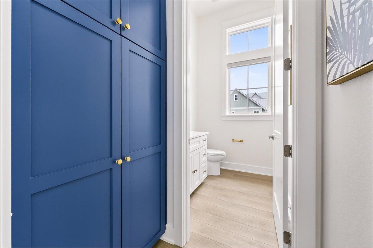A bathroom with a white toilet, a white sink, and a window.