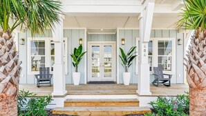 A house with a porch, two potted plants, and a number '404' on the wall. - Spirit of the Ocean 404 RET (Port Aransas)