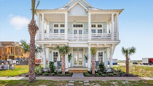 A two-story house with a balcony, a front porch, and a driveway. - Spirit of the Ocean 404 RET (Port Aransas)