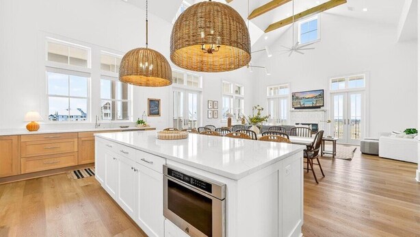 A spacious kitchen with a large island, white cabinetry, and a modern pendant light. - Always Summer 157 DEW (Port Aransas)
