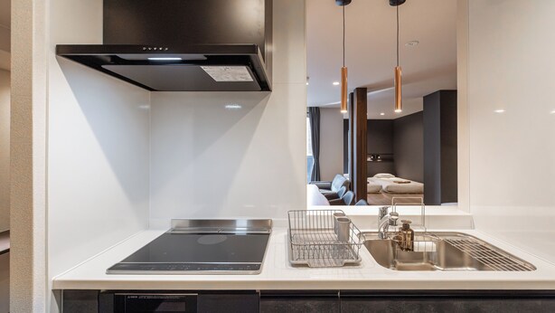 Una cocina moderna con horno empotrado, un lavabo con grifo y un escurreplatos.