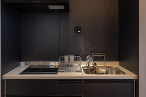 Una cocina moderna con un lavamanos de acero inoxidable, un escurreplatos y un horno empotrado.