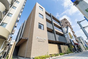 Un edificio de varios pisos con un cartel que dice 'RELA' y 'Kansaiwaseinjin'.