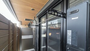 Habitación de hotel moderna con puerta corredera de vidrio, techo de madera y estructura de metal negro.