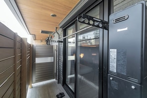 A modern hotel room with a sliding glass door, a wooden ceiling, and a black metal structure.