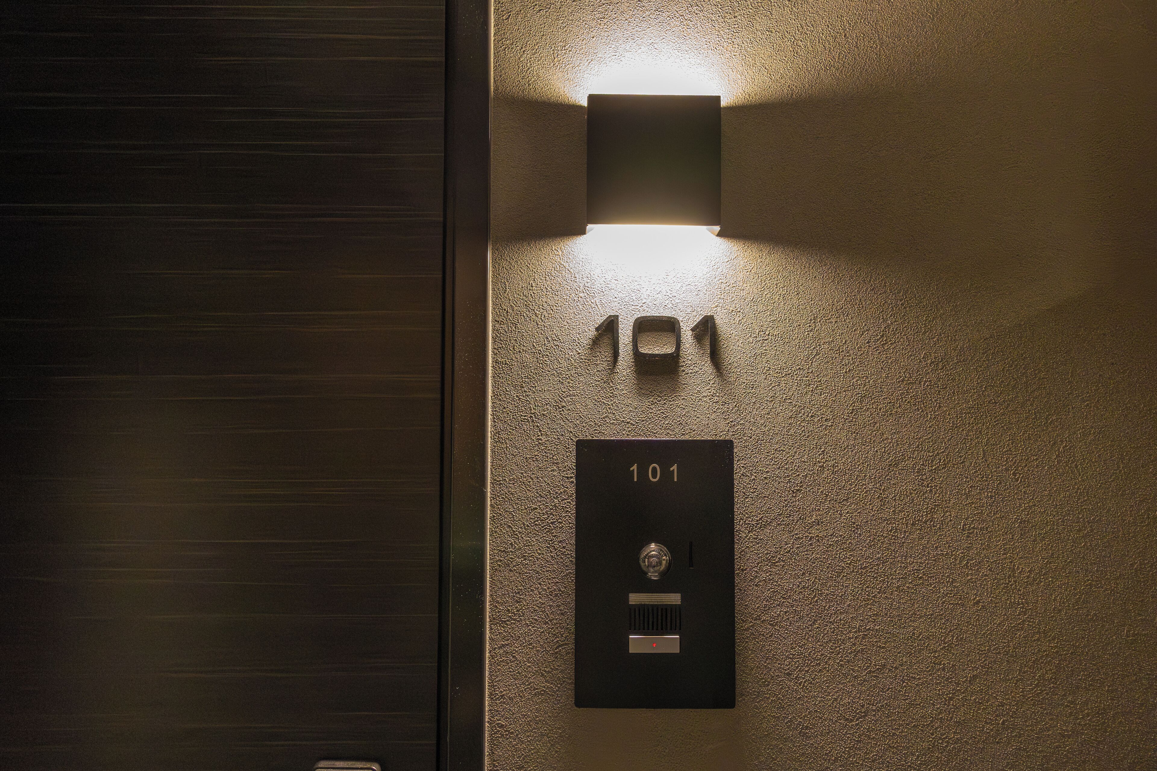 A wall-mounted light fixture above a door with the number '101' indicating a room number.