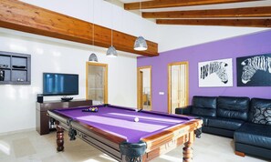 A room with a pool table, a television, a sofa, and artwork on the walls. - Villa Zaccori by Interhome (Moraira)