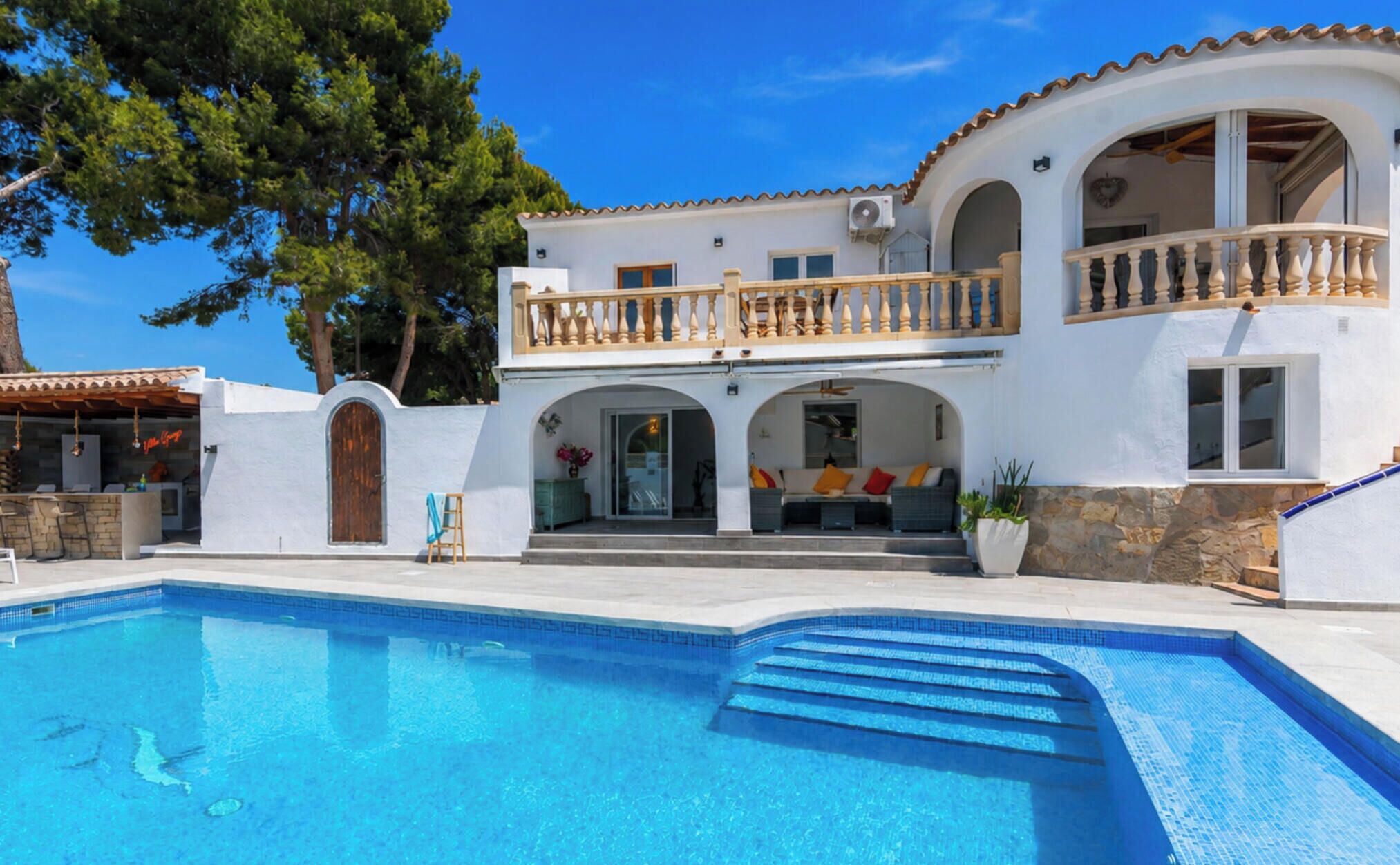 Un bâtiment à deux étages doté d’une piscine, d’un espace extérieur aménagé et d’un patio couvert.