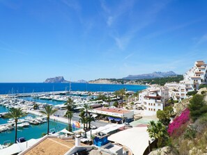A marina with boats, a coastal town, and mountains in the background. - Villa George by Interhome (Moraira)