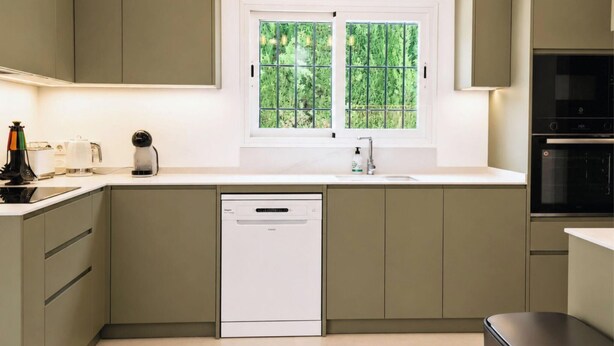 A kitchen with a dishwasher, a sink, and a window with a view of greenery. - Villa la Siesta by Interhome (Moraira)