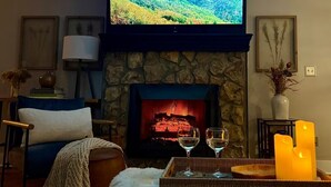 A cozy living room with a stone fireplace, a flat-screen TV, and a comfortable seating area. - Designer Boutique Retreat • 2 Private King Suites • Fireplace • View ... (Banner Elk)
