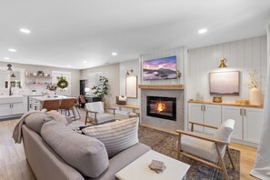 A modern living room with a fireplace, a dining area, and a kitchen. - The Perfect CDA Escape - Beach, Trails & Downtown All Within Walking Distance (Coeur d'Alene)