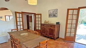 Un coin repas comprenant une table en bois, des chaises, un buffet et un tableau encadré accroché au mur.