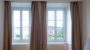 Ein Zimmer mit zwei Fenstern, einer Heizung und einem Bett.