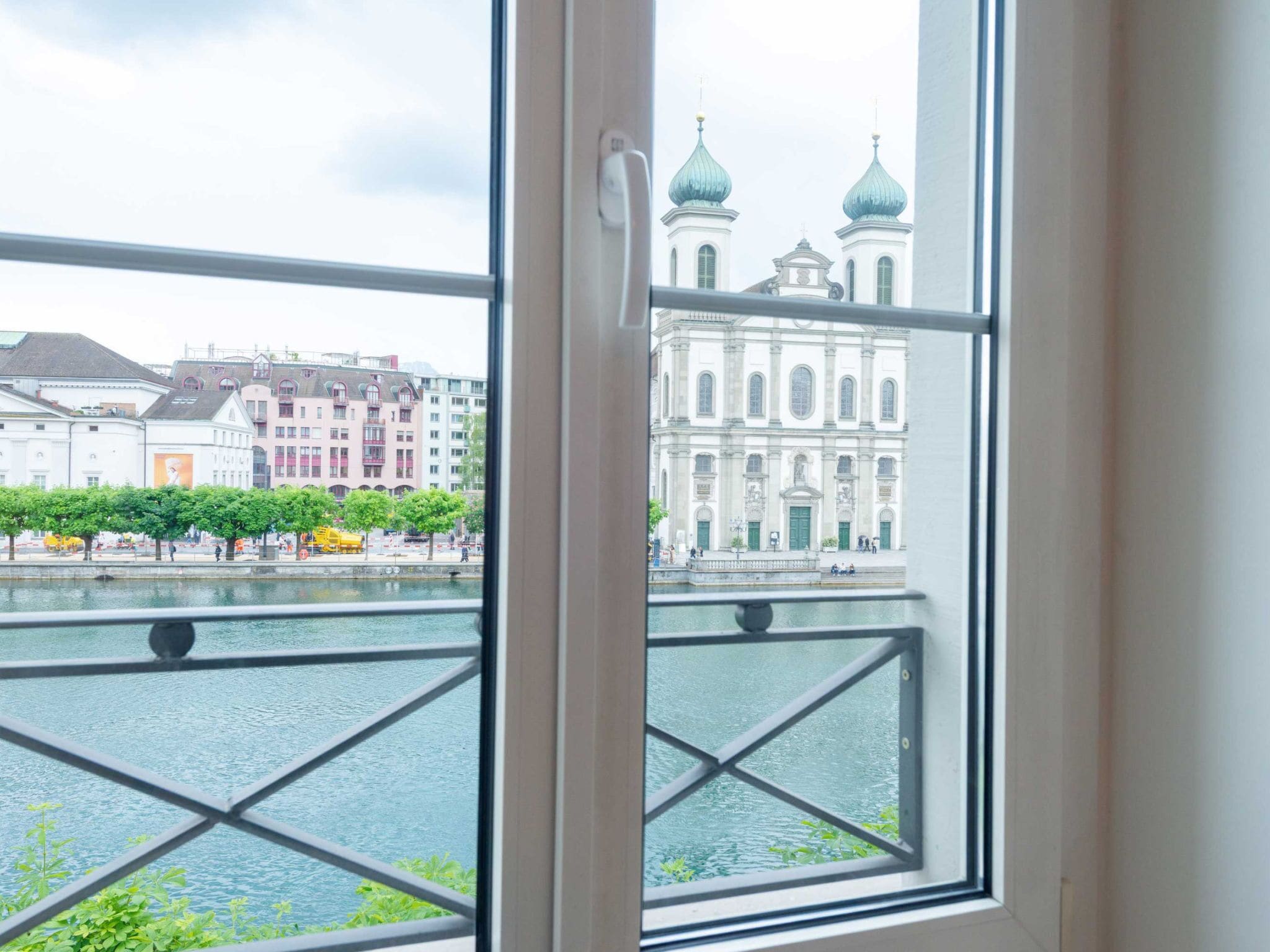 A view through a window of a river with buildings in the background.