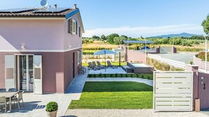 Une maison moderne dotée d’un patio, d’un espace salon extérieur et offrant une vue sur la campagne.