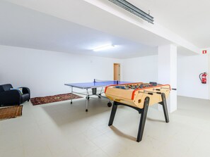 A room with a foosball table, a sofa, and a patterned rug. - Endless Summer Luxury Villa by Interhome (Almancil)