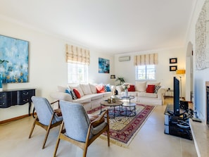 A spacious living room with two sofas, a coffee table, and a television. - Endless Summer Luxury Villa by Interhome (Almancil)