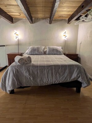 Ein Schlafzimmer mit einem Bett, zwei Nachttischen und zwei Wandlampen.