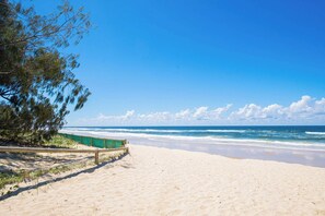 A beach with a wooden walkway, ocean view, and clear sky. - Level 29 Sky 2BR Ocean View Apartment (Surfers Paradise)