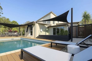 A modern house with a swimming pool, outdoor seating, and a shaded area. - Dreamworld Home with Pool, BBQ, WI-FI and Backyard (Oxenford)
