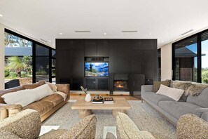 A modern living room with a fireplace, large TV, and comfortable seating.