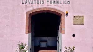 Entrada a LAVATOIO PUBBLICO con un arco de ladrillo y un cartel en la pared.
