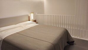 A bedroom with a bed, nightstand, wall-mounted light, and a white radiator. - Luxury b&b Villa Bellini: residential oasis 5 minutes from downtown (Catania)